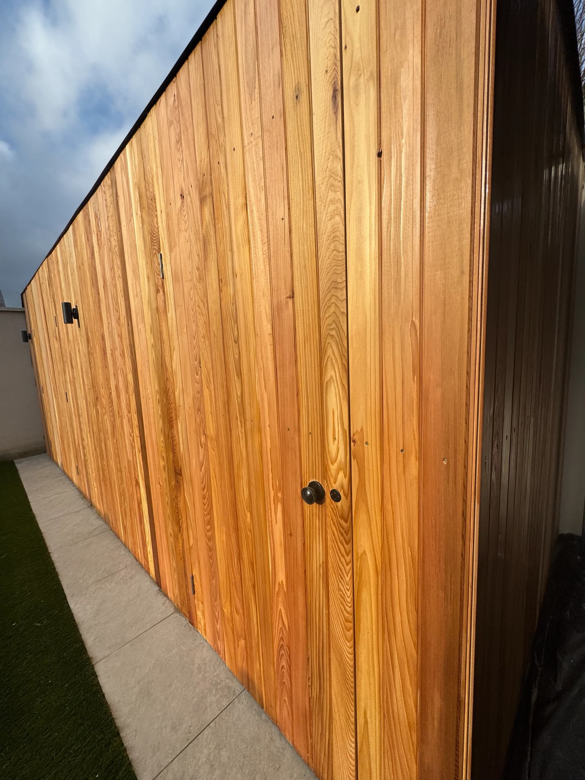 Timber slat fence above a white rendered planter
