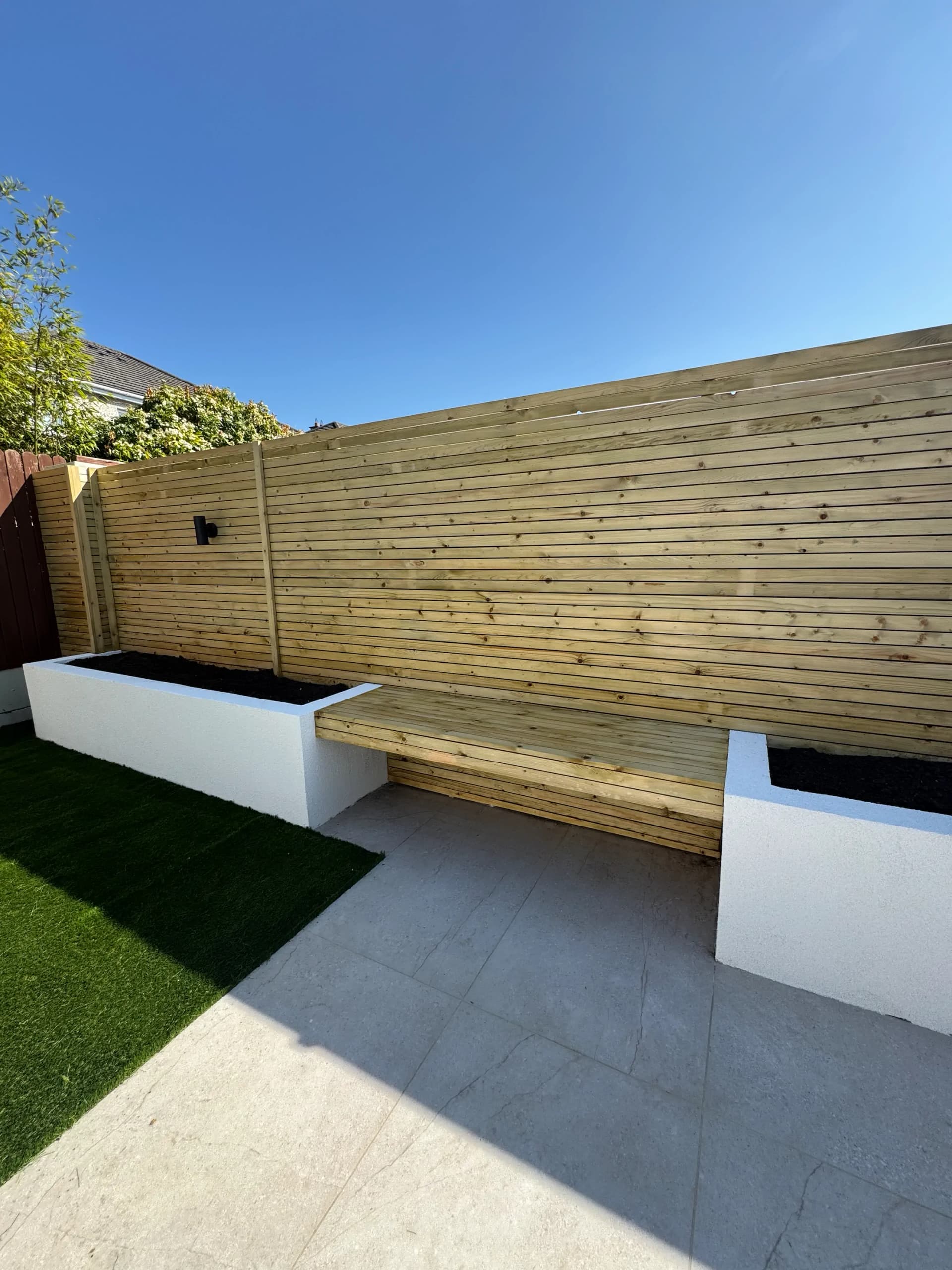 Timber fence panels enclosing an artificial grass lawn