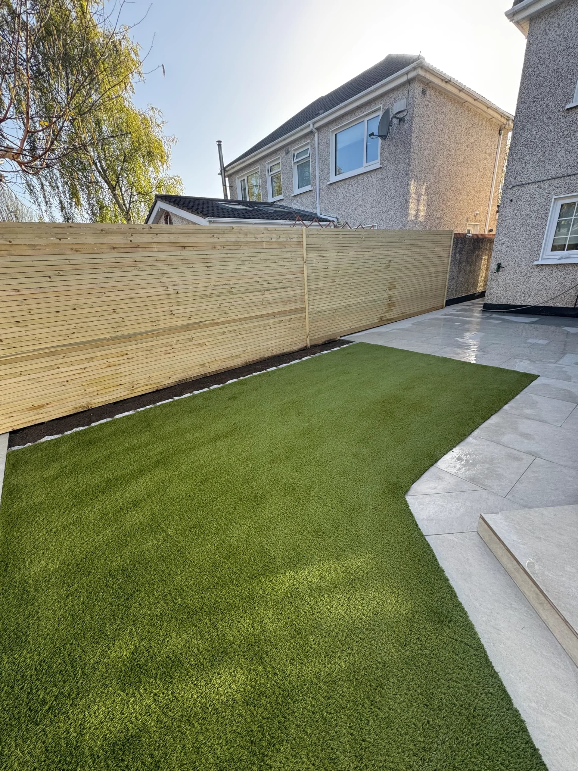 Timber fence with drainage channel and porcelain paving