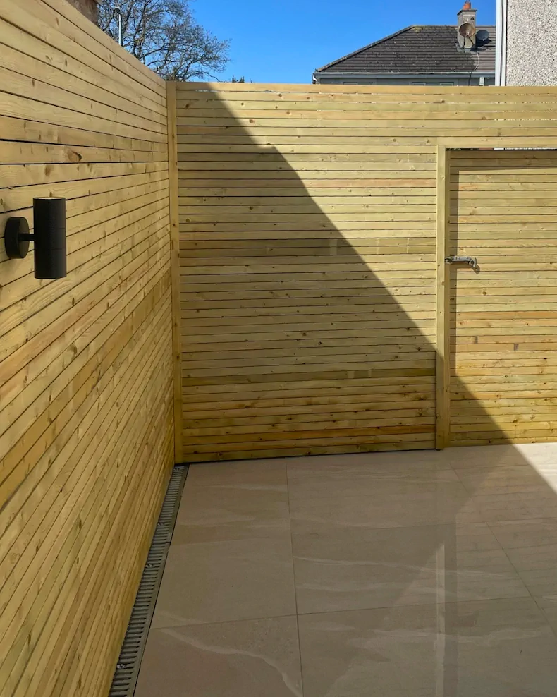 Painted timber fence boards with Japanese maple and patio