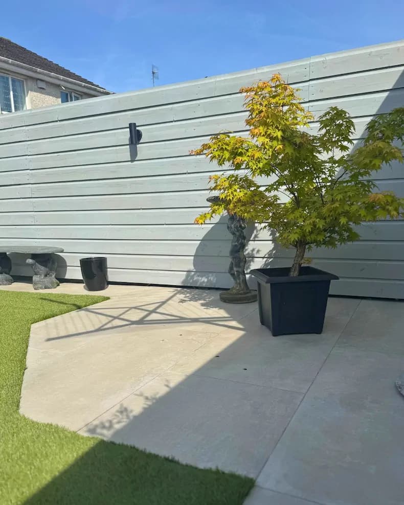 Light painted timber fence with lawn and seating area