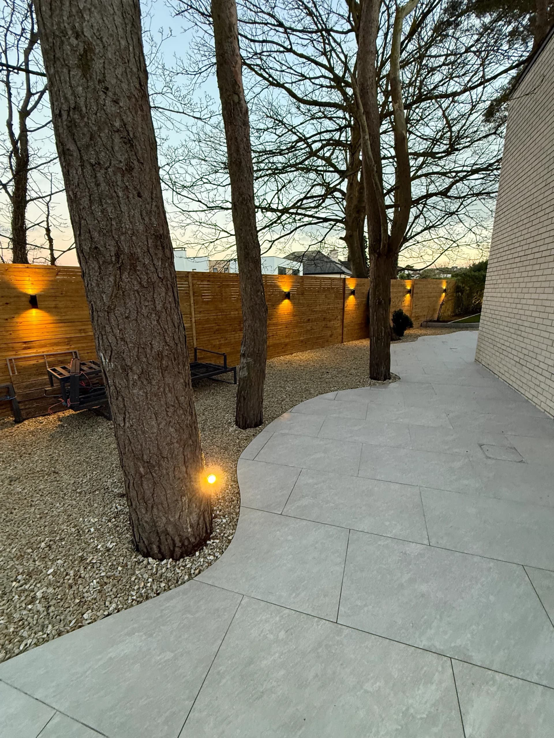 Dark painted timber fence with granite coping and raised bed