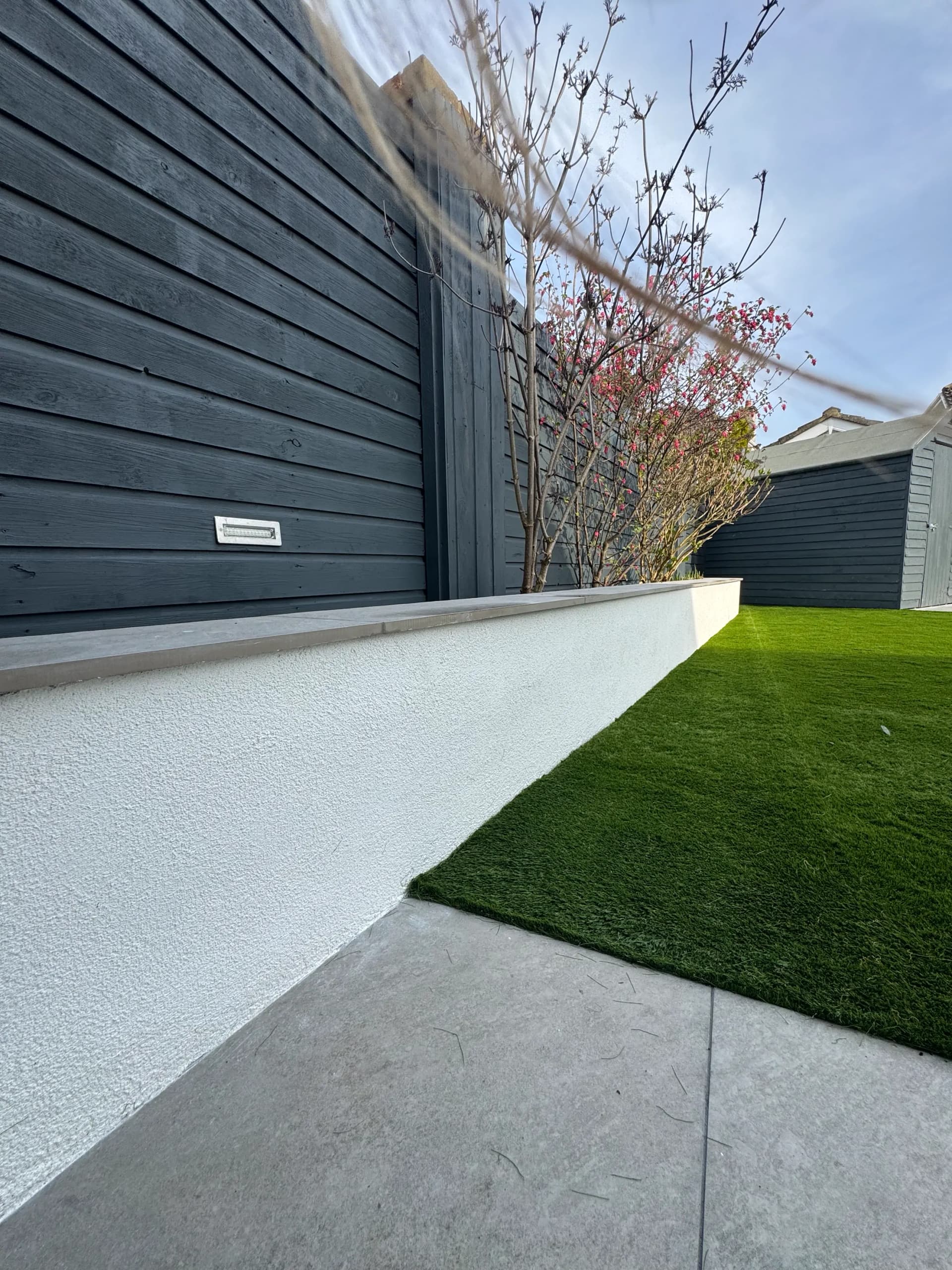 Charcoal timber fence with composite deck and artificial lawn