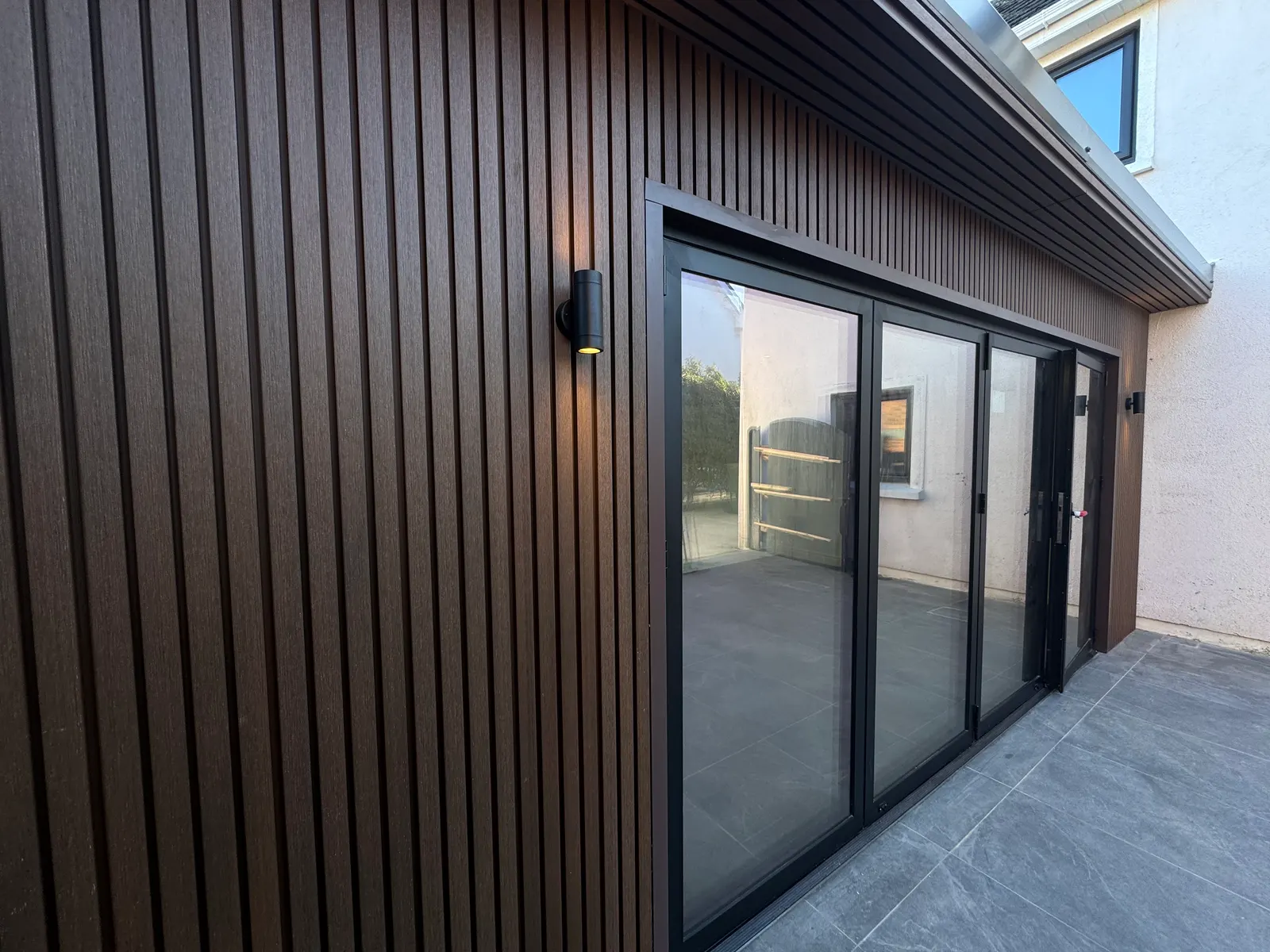 Close-up of composite slat cladding on a garden room with bifold doors