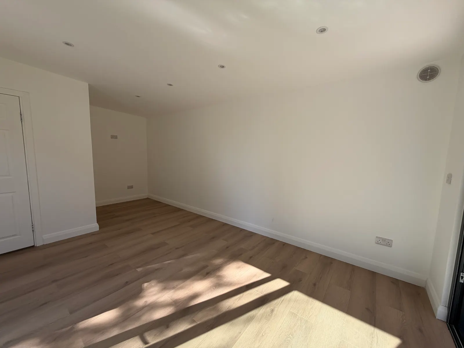 Garden room interior with wood-effect flooring and recessed lighting