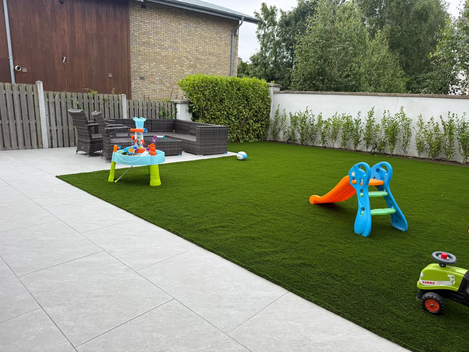Child-friendly garden with artificial grass play area and patio seating