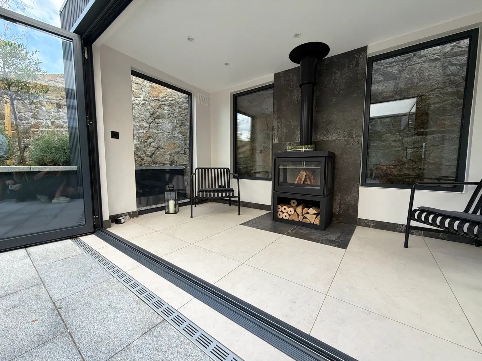 Glass garden room with wood burning stove and bifold doors open to the patio