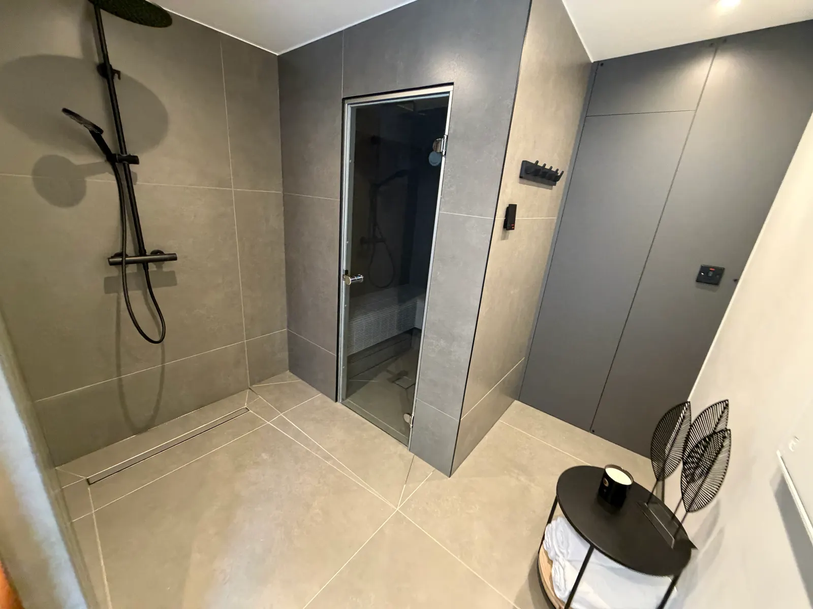 Shower area and steam room entrance finished in large format tiles