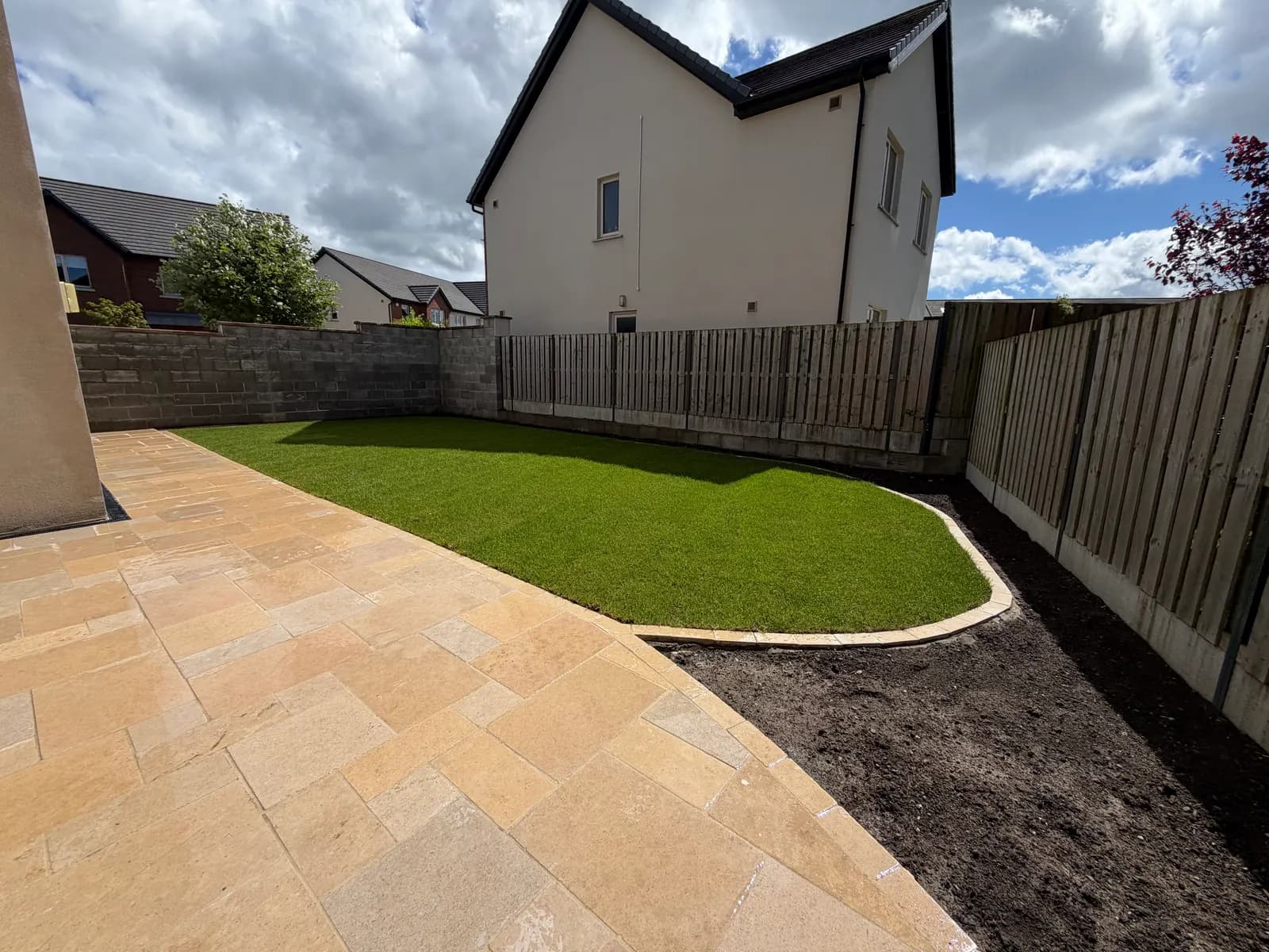 Fresh natural turf lawn with sandstone patio in a Dublin garden