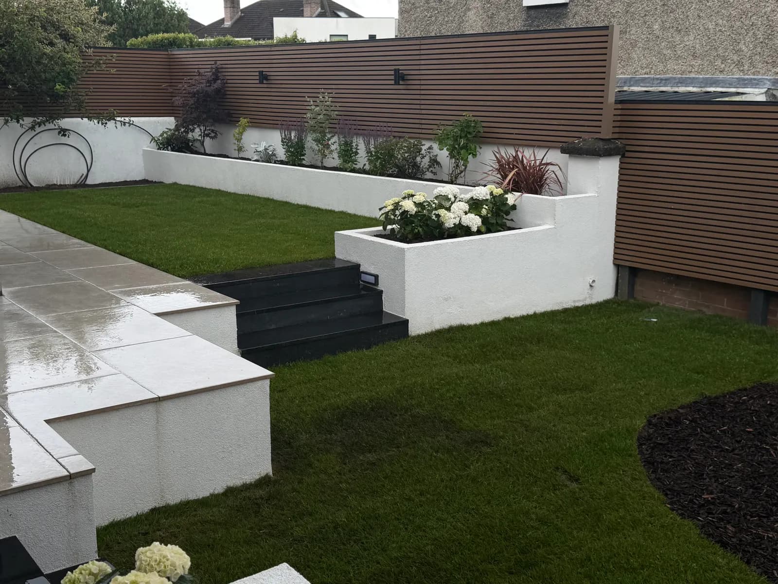 Natural turf lawn with rendered raised beds and granite steps
