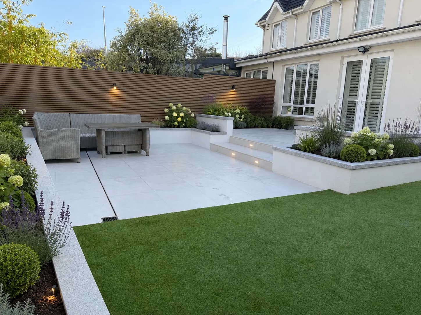 Premium garden with rendered raised beds, lit steps and porcelain patio
